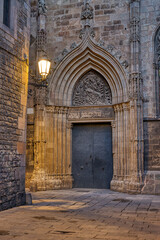 Street in the Gothic Quarter in Barcelona at twilight with a side entrance to the cathedral