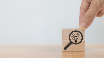 Hand holding a wooden cube with a light bulb,Strategic Strategic Business Review for Business Growth