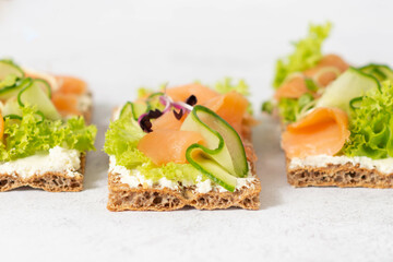 Homemade Crispbread toast with Smoked Salmon, Melted Cheese and cress salad. on white wooden board.