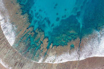 Aerial view of Sea waves reaching tropical beach landscape on Nusa Lembongan, close to Bali island, Indonesia.