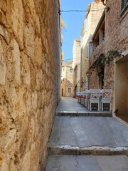 outdoor seating with table and chairs located in narrow streets of Hvar, Croatia