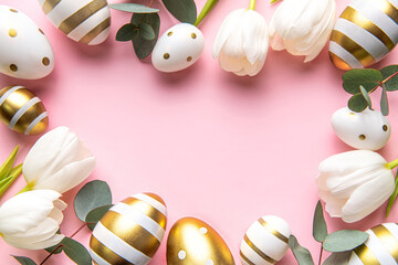 Easter golden eggs and white tulips on pink  background.