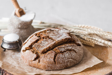 Fresh delicious bread close-up and salt. Freshly baked sourdough bread with a golden crust on a wooden board. The context of a bakery with delicious bread. Confectionery products.