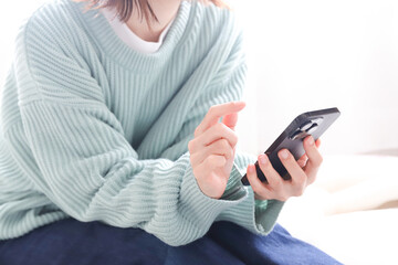 スマートフォンを操作する女性の手元