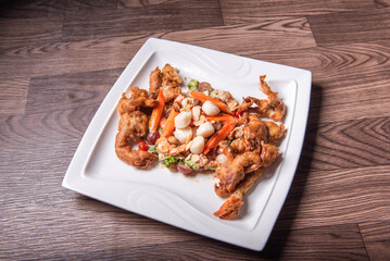chinese and western mixed seafood combination cold platter with deep fried soft shell crab scallop salad on wood table asian banquet halal menu