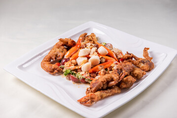 chinese and western mixed seafood combination cold platter with deep fried soft shell crab scallop salad on wood table asian banquet halal menu