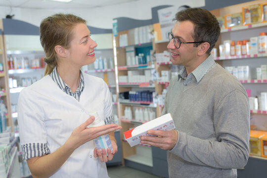 portrait of a beautiful female pharmacist helping her customer