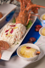 beautiful Deluxe Lobster Big cold Platter Combination with deep fried prawn honey chicken wing lobster salad herbal dim sum roll in flower plate decor on wood table asian banquet appetiser halal menu