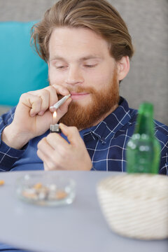 Young Man Smoking Marijuana At Home