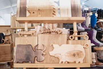 Handicrafts made of wood at the folk art fair. Cutting boards from different types of wood in the assortment