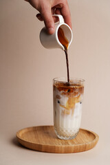 Iced coffee cocktail glass on pastel background