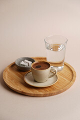 Obraz na płótnie Canvas Coffee cup and glass of water on wooden tray