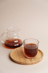 Glass of coffee and coffee pot on white background