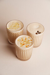 Three Vanilla milkshake glass with orange, lemon and coffee
