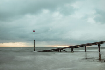 A beautiful sunrise scene by the sea with a small wooden structure in the foreground