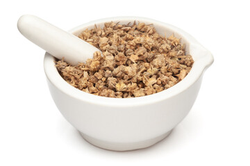 Closeup of Dry gokhuru (tribulus terrestris) fruits, in white ceramic mortar and pestle, isolated on white background.