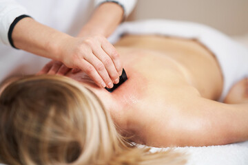 Obraz na płótnie Canvas Woman having a gua sha massage in salon