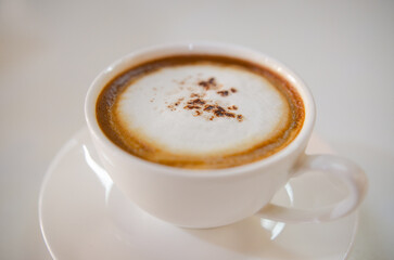 White tabletop with cappuccino coffee and soft milk foam