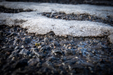 Wet asphalt road and melting snow. Spring and weather conditions