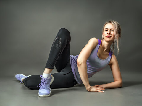 Sportswear girl is engaged fitness. Stretching of her legs.