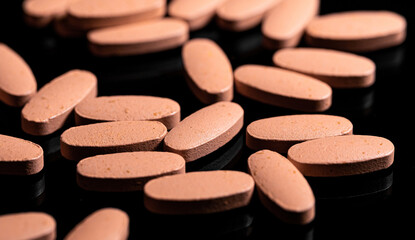 Close up of Multi Vitamin tablet on a reflective black backgroun