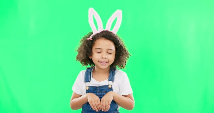 Kids, easter and funny face with a girl on a green screen background in studio feeling silly while having fun. Children, bunny and holiday with a cute little female child playing on chromakey mockup