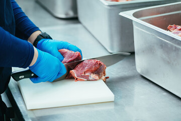 Restaurant Chef Cutting Piece of Red Meat with Knife