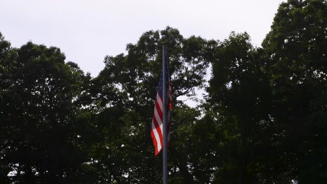 United States flag hanging from a flagpole on a hot and hazy summer day.