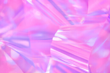 Soft focused, blurred close-up of ethereal pastel neon purple, lavender, pink holographic metallic foil background. Abstract modern surreal futuristic disco, rave, techno, festive dreamlike backdrop