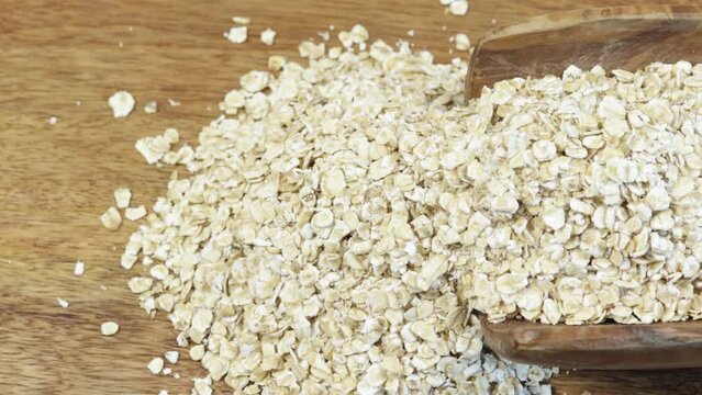 flocons d'avoine, en gros plan, dans une cuill&egrave;re en bois