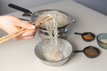 A girl is cooking udon 