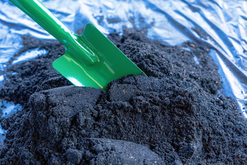 Preparation of soil mixture from fertile compost, humus and vermiculite on  black garbage bag floor...