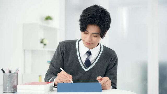 タブレットで勉強する男子学生