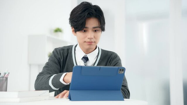 タブレットで勉強する男子学生