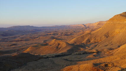 Fototapeta na wymiar Sunrise view of HaMakhtesh HaGadol the big crater, in the Negev Desert, Southern Israel. It is a geological landform of a large erosion cirque