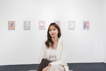 Woman visiting art gallery her looking pictures on wall watching photo frame painting at artwork museum people lifestyle concept.