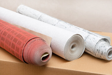 Three rolls of wallpaper in various colors and textures. Home renovation concept. Close up