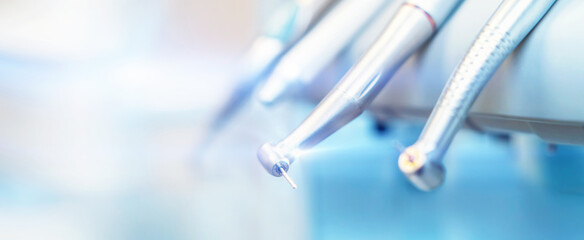Closeup photo of dental handpieces and equipment on dental chair with blured background. - Powered by Adobe