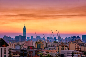 Obraz premium Colorful sunset over big city, downtown skyline and residential area. 