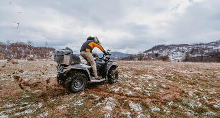 A man drives an ATV in the mud. Drift driving an ATV quad in mud and snow