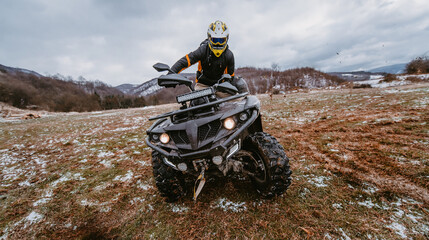 Fototapeta na wymiar A man drives an ATV in the mud. Drift driving an ATV quad in mud and snow