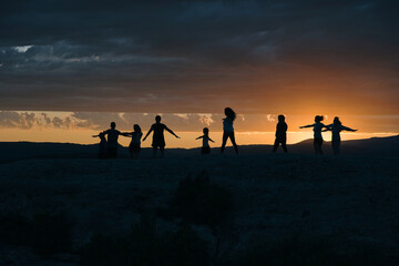 Grupo de gente haciendo yoga en la puesta de sol
