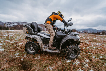 A man drives an ATV in the mud. Drift driving an ATV quad in mud and snow © Minet
