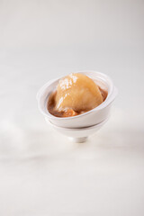 hot braised premium shark's fin soup and crab meat scallop in convoy superior stock white bowl on red cloth background chinese seafood banquet halal menu