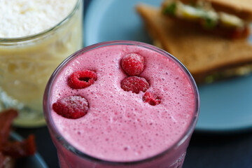 Refreshing raspberry milkshake served for lunch in a restaurant. Delicious smoothie with raspberries for detox diet