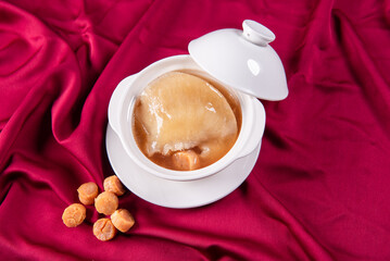 hot braised premium shark's fin soup and crab meat scallop in convoy superior stock white bowl on red cloth background chinese seafood banquet halal menu