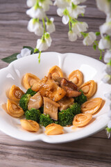 expensive premium braised head abalone with sea cucumber and flower mushroom broccoli in thick golden sauce on wood table asian chinese halal deluxe banquet seafood menu 