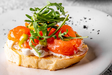 Bruschetta with salmon, cream cheese and arugula on plate