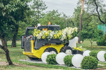 Floral park design. Excavator decorated with lilies