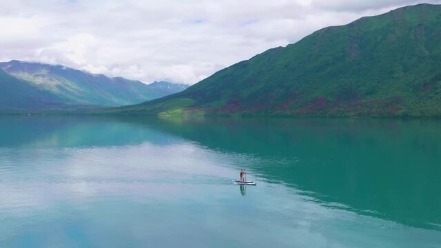 A couple paddle boarding on Kenai Lake in Alaska.